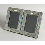 A PAIR OF ART NOUVEAU STYLE SILVER AND ENAMEL PHOTOGRAPH FRAMES 7.5ins x 5.5ins