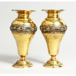 A GOOD PAIR OF SILVER GILT VASES, cast with a band of fruiting vines, 6.5ins high London, 1907,