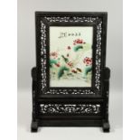 A CHINESE PORCELAIN PLAQUE painted with peonies, in a wooden stand.