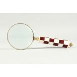 A MAGNIFYING GLASS WITH CHEQUERED HANDLE