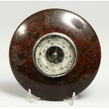 A 20TH CENTURY SERPENTINE STONE CIRCULAR ANNEROID BAROMETER. 7ins diameter.