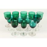 TWELVE MIXED VICTORIAN GREEN TINTED WINE GLASSES.