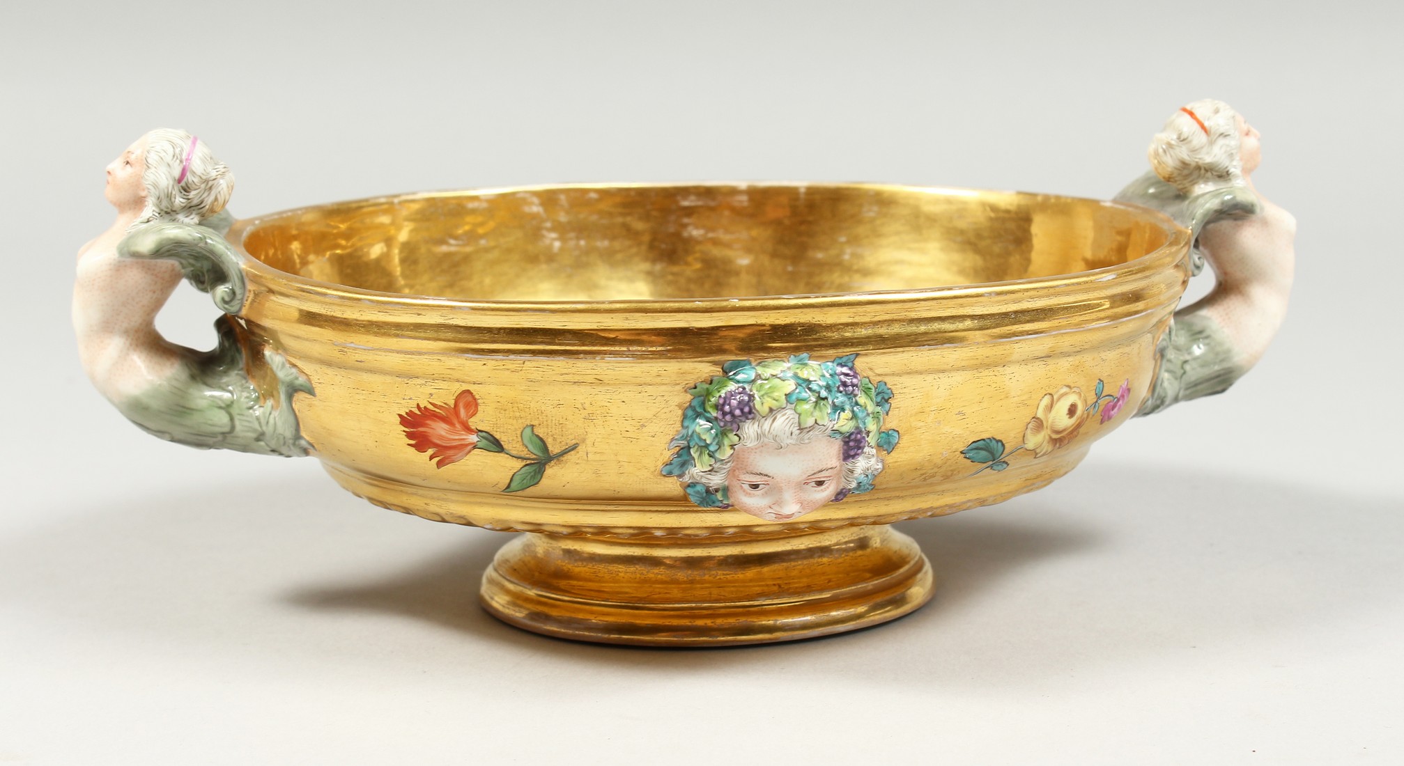 A GOOD BERLIN GILT GROUND OVAL BOWL with mermaid handles, masks and flowers. 8.5ins long