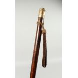 A LONG VICTORIAN TAPERING CEREMONIAL CANE with gilded handle and rope. 48ins long