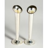 A PAIR OF SILVER FLOWER VASES on loaded circular bases. 7.5ins high, London, 1962.