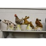 Four unusual pottery groups of a pig, a chicken and two hares.