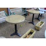 A pair of circular brass topped tables.