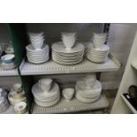 A quantity of plain white dinner plates and serving bowls.