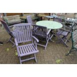 A painted circular folding wooden garden table with six folding chairs.