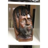 A carved wood bust of a bearded man.