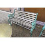 A garden bench with green [painted cast metal ends.