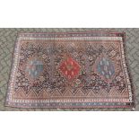 A SHIRAZ RUG, with three large central medallions, in a narrow border. 8ft 7ins x 5ft 9ins