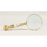 A MAGNIFYING GLASS with a gilt and mother of pearl handle.