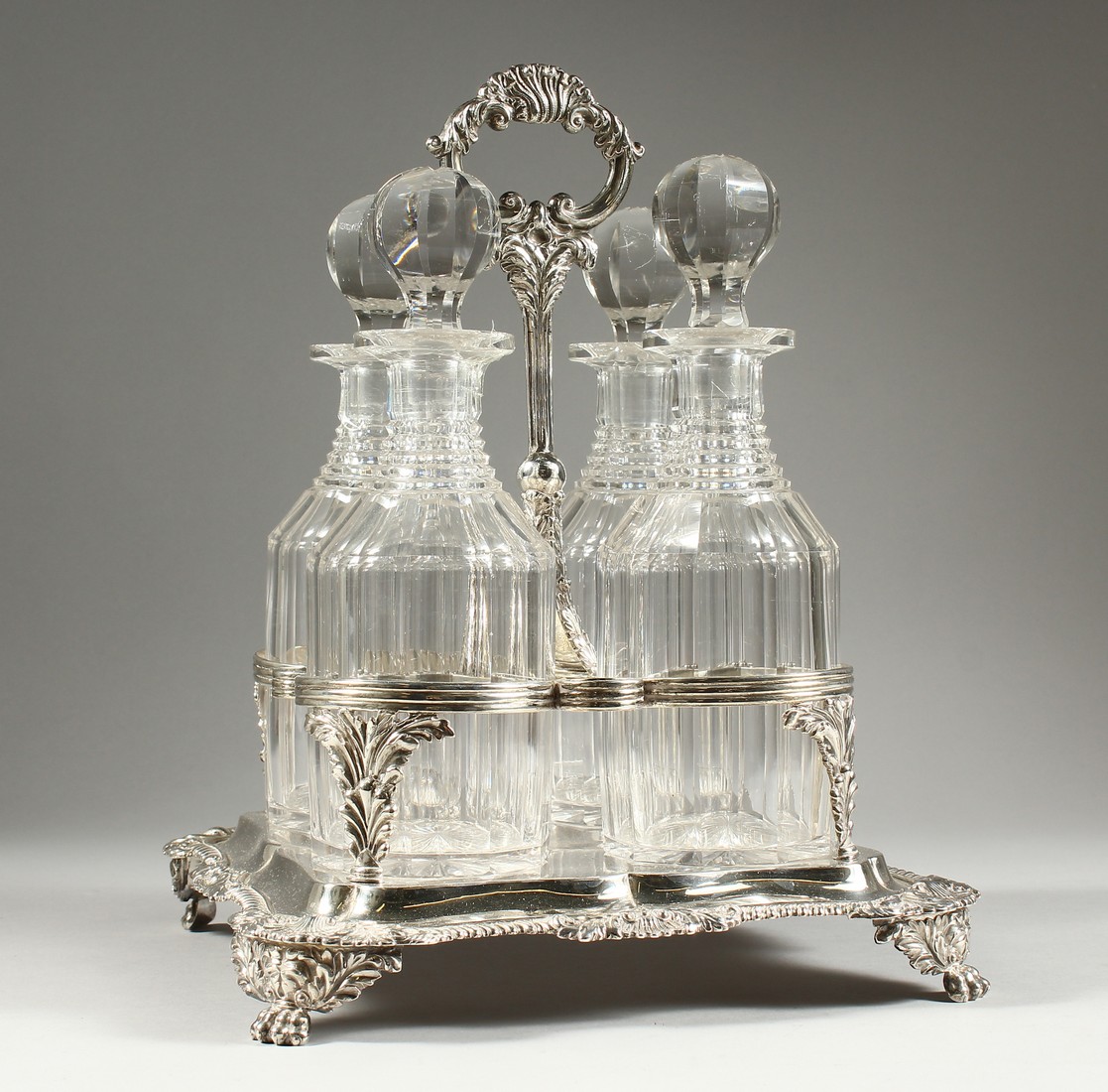 .A GOOD GEORGE III FOUR BOTTLE CRUET filled with four whisky decanters and stoppers. The stand