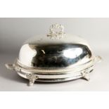 A LARGE PLATED OVAL MEAT DISH AND COVER with gadrooned edge, carrying handles and four curving