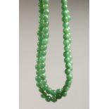 A STRING OF JADE BEADS 24ins long.