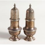 A PAIR OF SILVER PEDESTAL SUGAR SIFTERS. 6.5ins high, London 1968 & 1974 Weighs 14ozs.