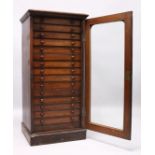A VERY GOOD VICTORIAN MAHOGANY COLLECTORS CABINET, with glass front door enclosing 14 glass top