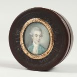 A GEORGIAN EBONY CIRCULAR BOX, the top painted with an oval of a gentleman. 2.25ins diameter.