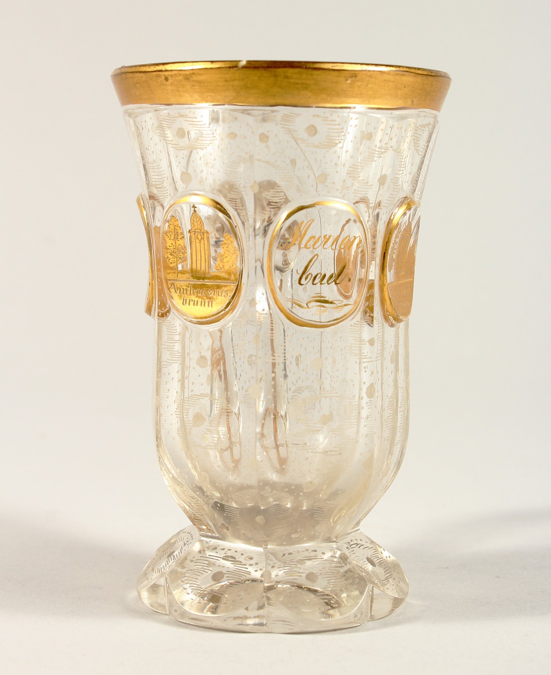 A GOOD BOHEMIAN GILT DECORATED GOBLET with handle, with a scene of buildings 4.75ins high.