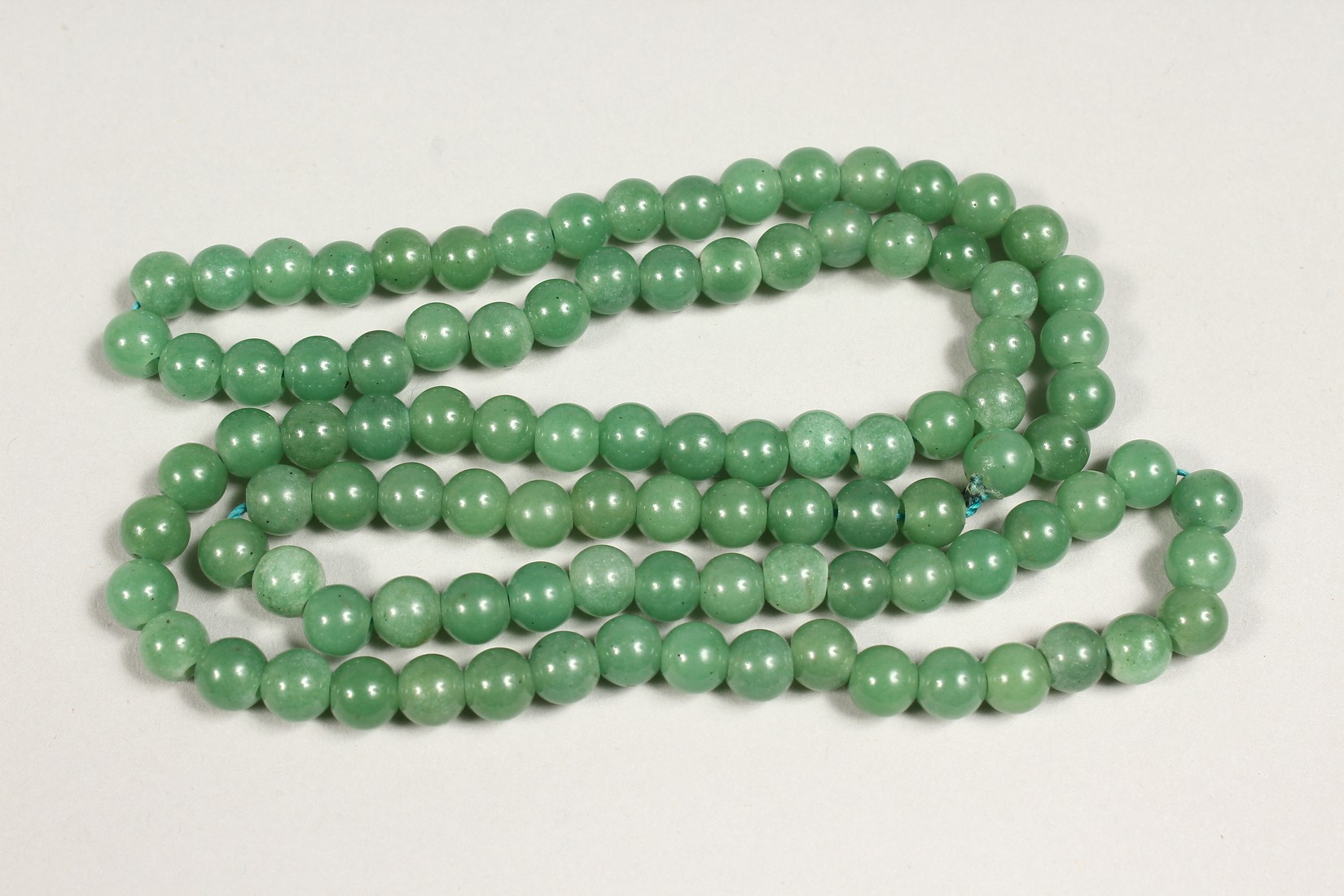 A STRING OF JADE BEADS 24ins long. - Image 3 of 3