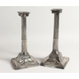 A GOOD PAIR OF GEORGE III SILVER CLASSICAL CANDLESTICKS with Corinthian columns, square loaded bases