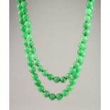 A VERY GOOD SET OF JADE BEADS with a 18ct gold clasp 44ins long.