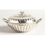 A GEORGE II SILVER CIRCULAR TWO HANDLED ECULLE and cover with fluted decorations. 5.5ins diameter