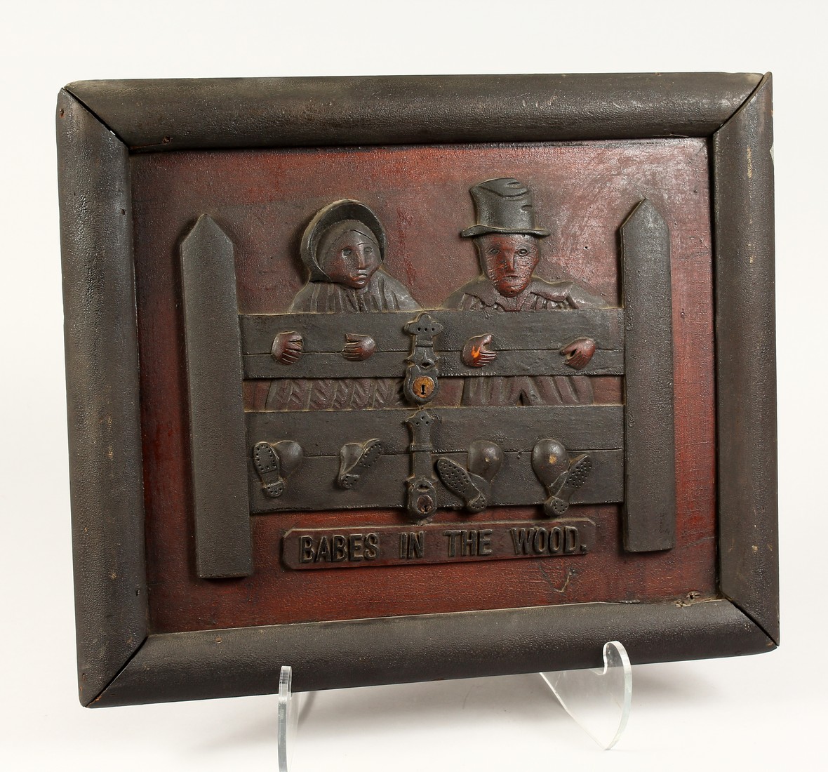 AN AMERICAN WOODEN FOLK ART PANEL Two figures in the stocks, 'Babes in the Wood 15ins x 17ins