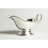A GEORGE V SILVER SAUCE BOAT with reeded edge and handle. London 1934. 19cm long - 197g