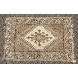 A PERSIAN RUG brown and cream with large medallions. 6ft 6ins long x 4ft 6ins wide