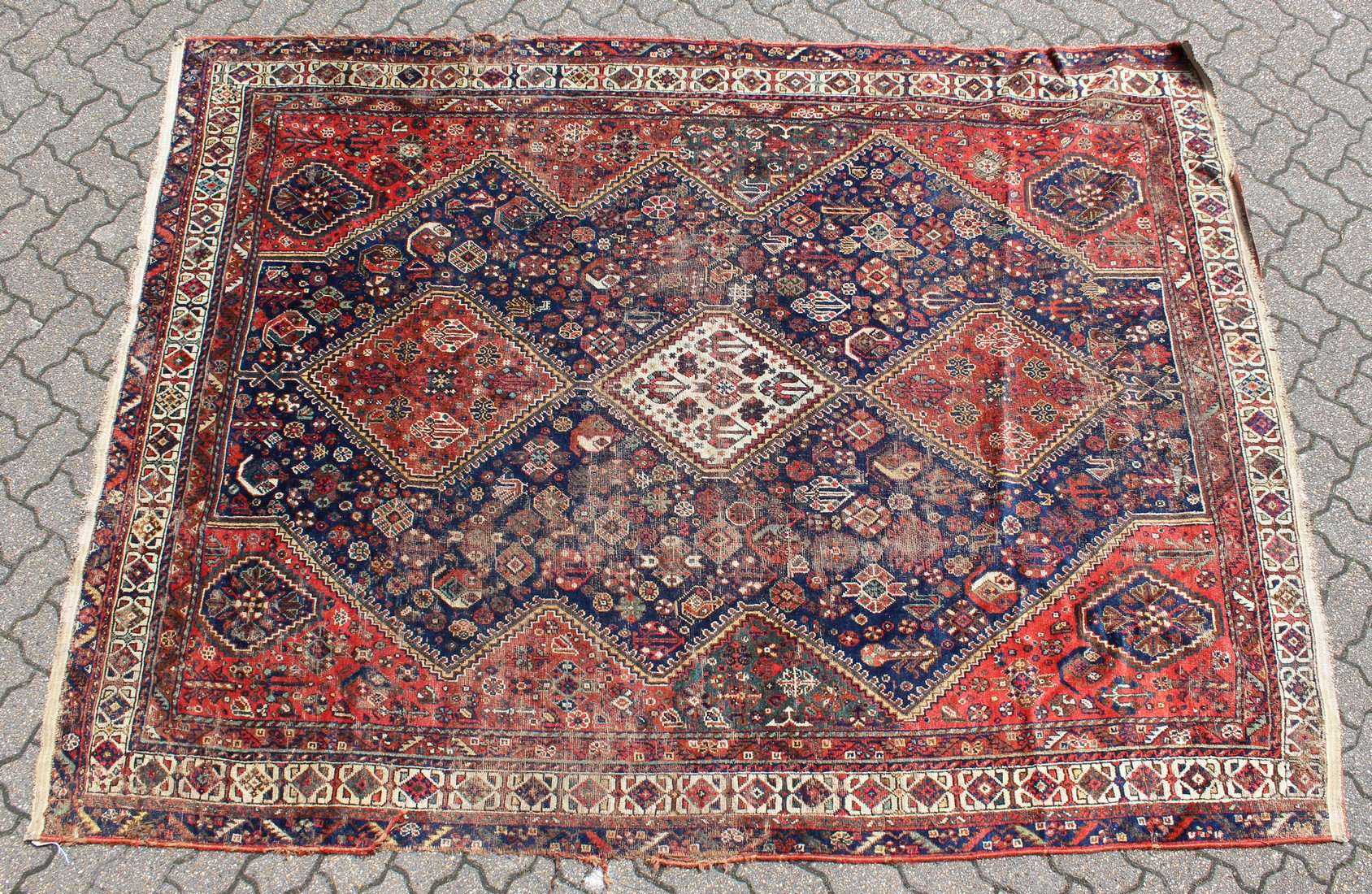 A PERSIAN CARPET with three large diamond design, in red and blue. 9ft long x 6ft 10ins wide.
