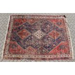 A PERSIAN CARPET with three large diamond design, in red and blue. 9ft long x 6ft 10ins wide.