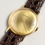AN 18CT GOLD HOUSMANN & CO. WRISTWATCH with leather straps.