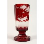 A BOHEMIAN RUBY TINTED GOBLET etched with deer. 7ins high.