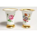 A GOOD PAIR OF MEISSEN TRUMPET SHAPED VASES edged in gilt and painted with roses. Cross sword mark