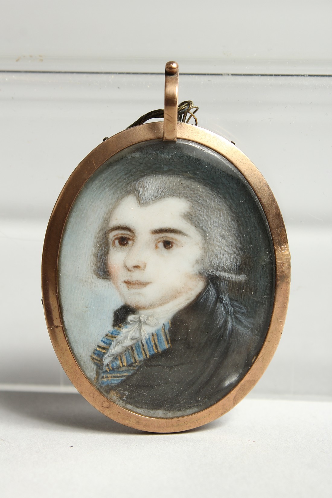 A GEORGIAN OVAL MINIATURE OF A YOUNG MAN, the reverse with plated hair. 1.25ins x1.25ins - Image 2 of 5