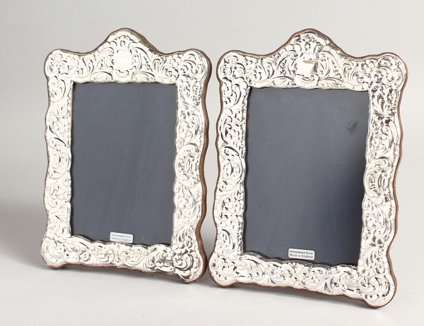 A PAIR OF SILVER REPOUSSE PHOTOGRAPH FRAMES 7.5ins x 5.5ins