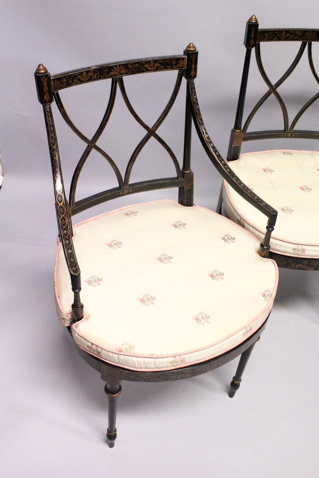 A SET OF FOUR BLACK AND GILT CHAIRS, two with arms, with cross fret backs and cane seats. - Image 3 of 4