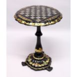 A VICTORIAN BLACK AND GILT PAPIER MACHE TILT TOP GAMES TABLE, with inlaid chess board in mother of