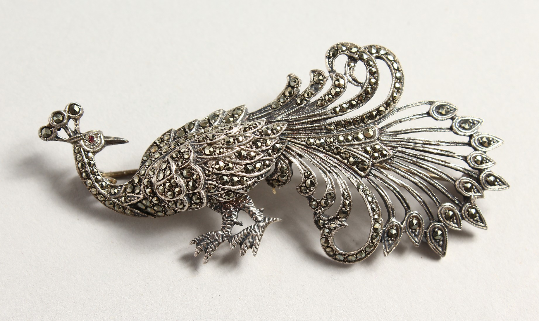 A SILVER AND MARCASITE PEACOCK BROOCH