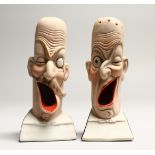 A PAIR OF POTTERY MEN'S HEADS ASHTRAYS. 5in high.