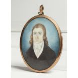 AN GEORGIAN OVAL MINIATURE OF A YOUNG MAN, the reverse with plated hair. 2.5ins x 2ins.