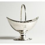 A GEORGE III SILVER BOAT SHAPED SUGAR BASKET with reeded swing handle, crested. London 1788, maker