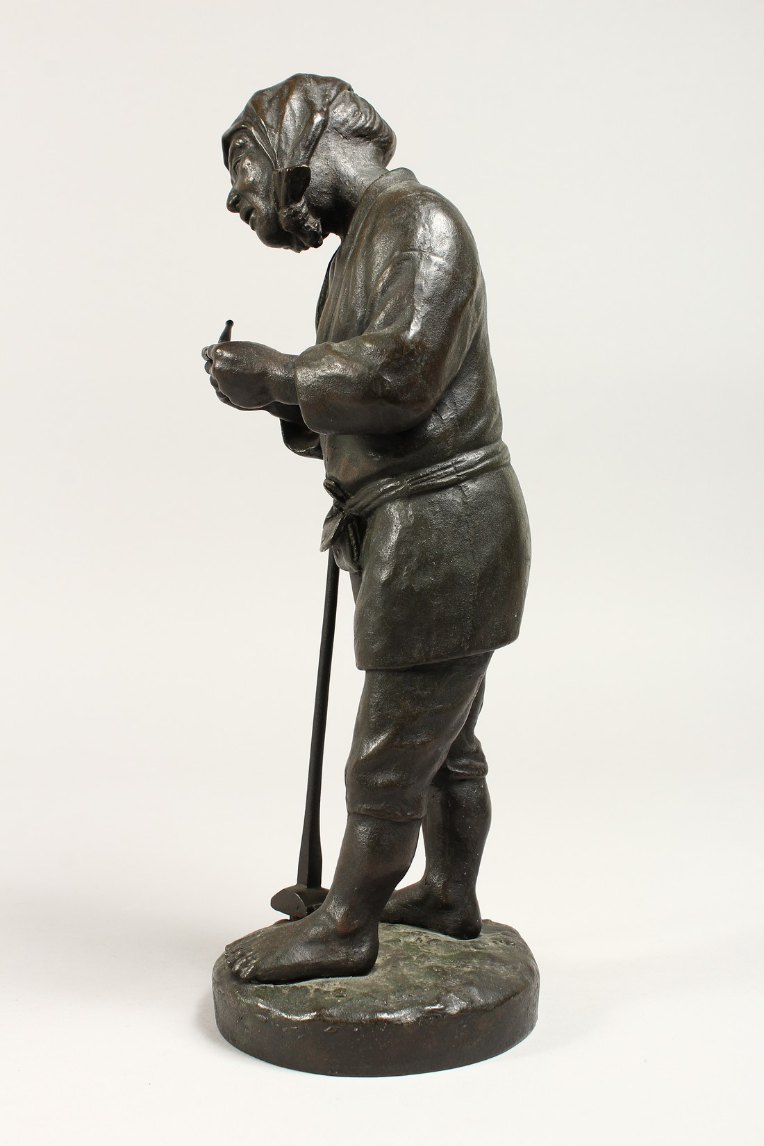 A JAPANESE BRONZE STANDING FIGURE OF A MAN holding a pipe and shovel. 12ins high. - Image 2 of 5