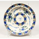 A MAJOLICA BLUE AND GREEN TIN GLAZE CIRCULAR DISH with tulips. 12ins diameter