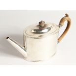 A GEORGE III PLAIN SILVER OVAL TEA POT and cover with wooden handles. London 1789, maker I. O.