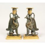 A PAIR OF THOMAS HOPE DESIGN GRIFFIN CANDLESTICKS 8.5ins high.