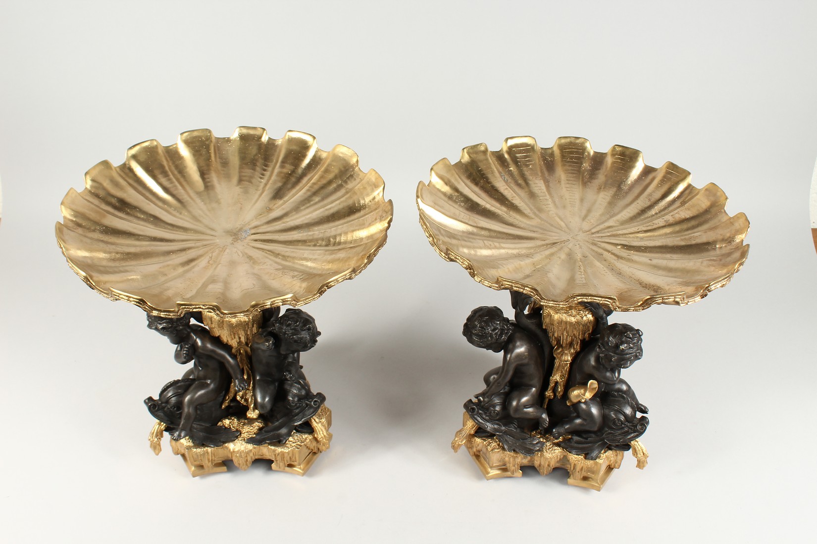 A GOOD PAIR OF BRONZE AND GILT BRONZE COMPORTS with shell shaped tops, three cupid supports. 13ins - Image 2 of 5