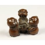 A GROUP OF THREE BRONZE PIGS PLAYING DICE 2.5ins